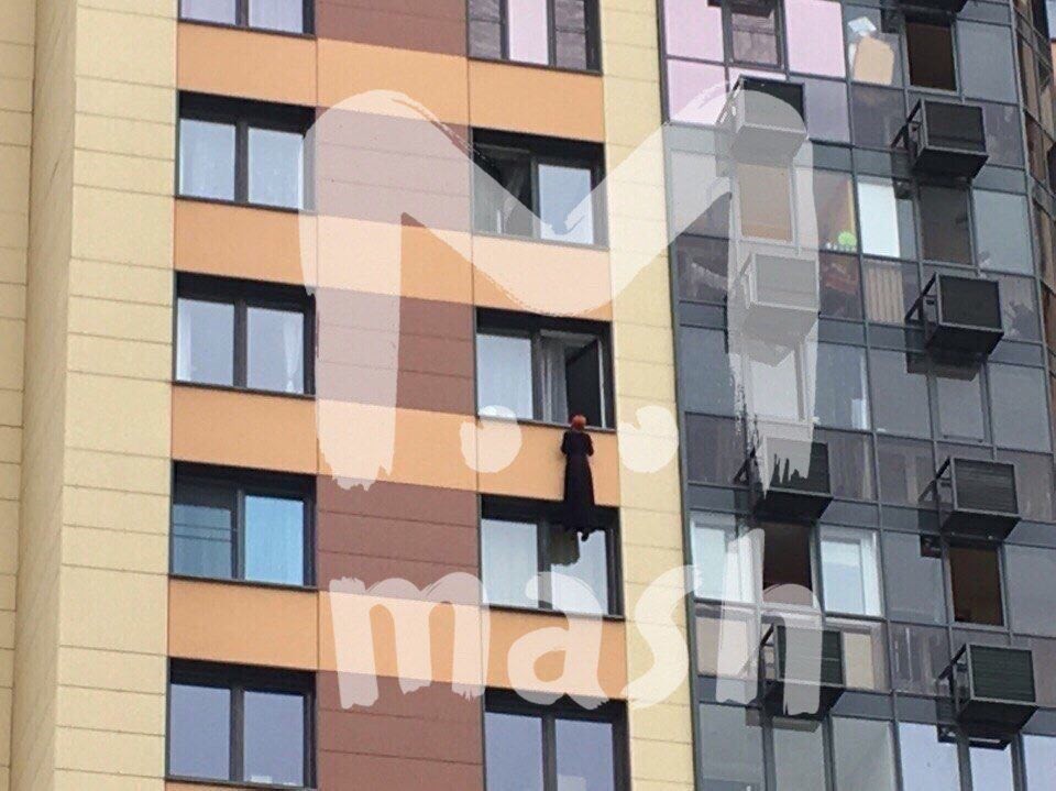 В Новой Москве девушка висит на фасаде дома на глазах у прохожих В Новой Москве девушка висит на фасаде дома на глазах у прохожих